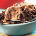 brownie cream cheese pudding cake crock pot recipe in a blue bowl with a spoon