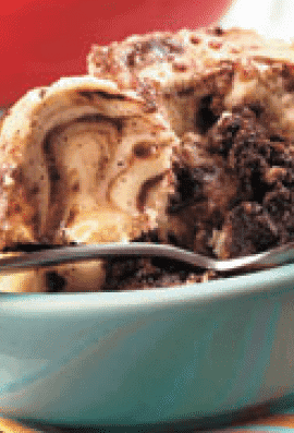brownie cream cheese pudding cake crock pot recipe in a blue bowl with a spoon