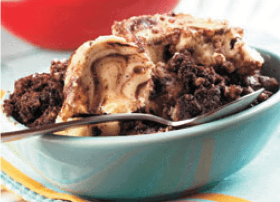 brownie cream cheese pudding cake crock pot recipe in a blue bowl with a spoon