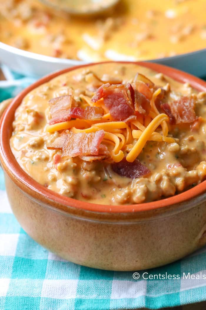 Bacon cheeseburger dip in a bowl with bacon and cheese on top