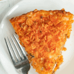 Slice of Doritos pie on a plate with a fork