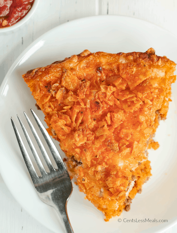 Slice of Doritos pie on a plate with a fork