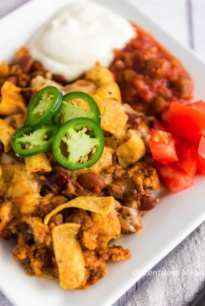 Frito pie on a plate topped with jalapenos