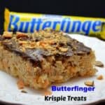 Butterfinger Rice Krispie Treats on a white plate with butter finger bar in the background