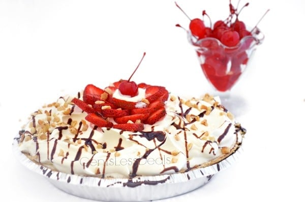 banana split pie drizzled with chocolate and nuts on top with strawberries