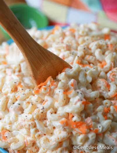 Classic macaroni salad in a bowl with a wooden spoon