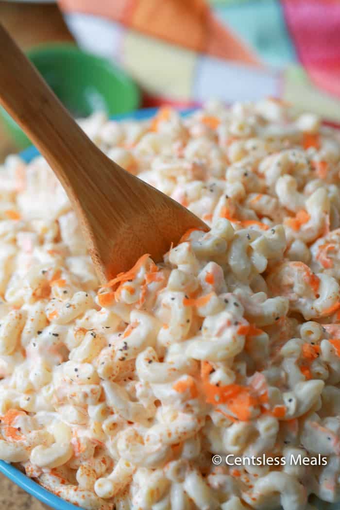 Classic macaroni salad in a bowl with a wooden spoon