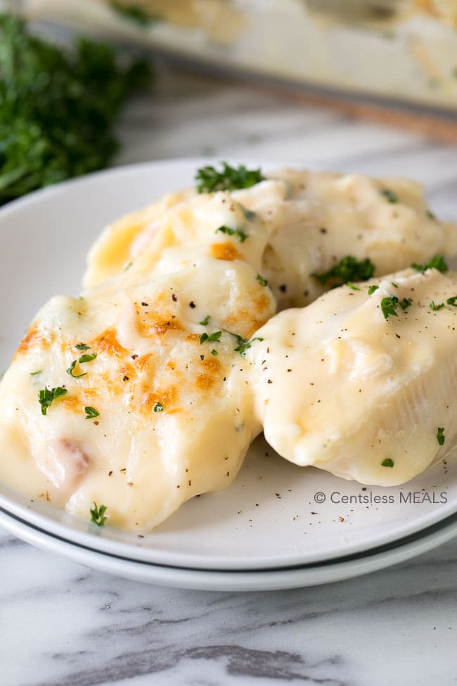 Cheesy chicken stuffed shells on a plate with parsley