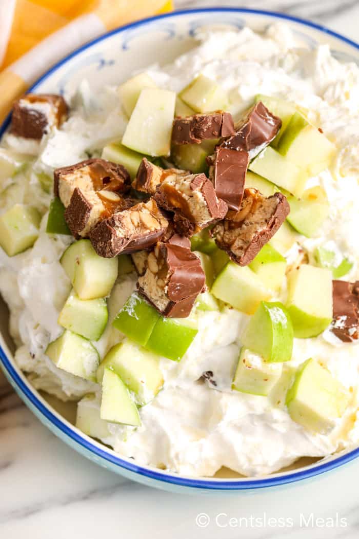 Snickers salad in a bowl on a marble board