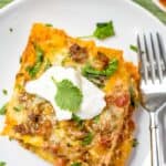 Taco bake on a white plate with a fork and cilantro