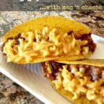 Sloppy joe tacos with mac and cheese on a white serving plate with writing
