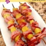 Grilled Hawaiian kabobs on a white serving plate with a title