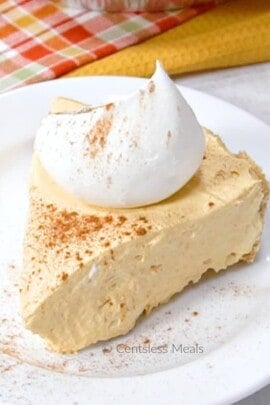 No bake pumpkin pie on a white plate with whipped cream