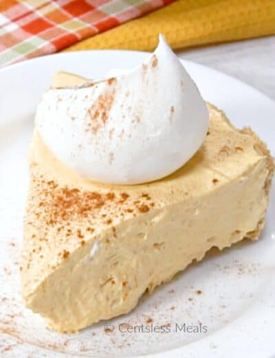 No bake pumpkin pie on a white plate with whipped cream