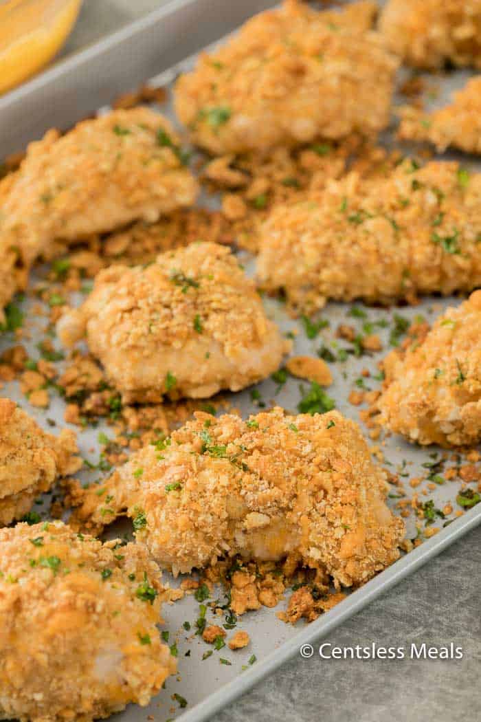 Ritz cracker chicken on a baking sheet with parsley on top