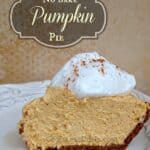 Cream cheese pumpkin pie on a white plate with whipped cream and writing