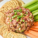 Bacon Ranch Cheeseball on a plate with crackers, celery and carrots