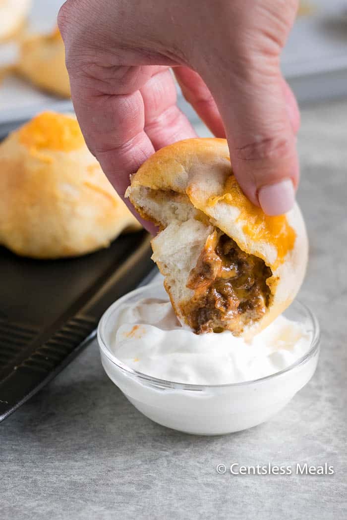 Biscuit Taco Pockets being dipped in sour cream