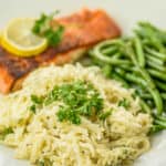 Garlic pasta on a plate with fish and green beans