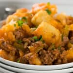 Sloppy joe tater tot casserole on a white plate garnished with parsley