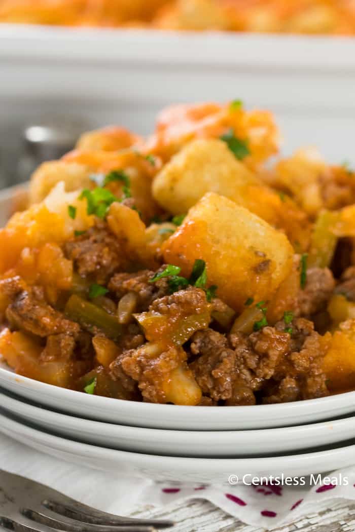 Sloppy joe tater tot casserole on a white plate garnished with parsley