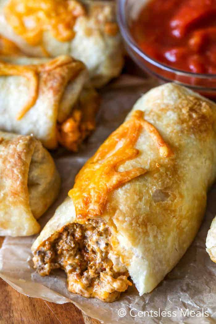 Taco pockets on parchment paper with salsa in the background