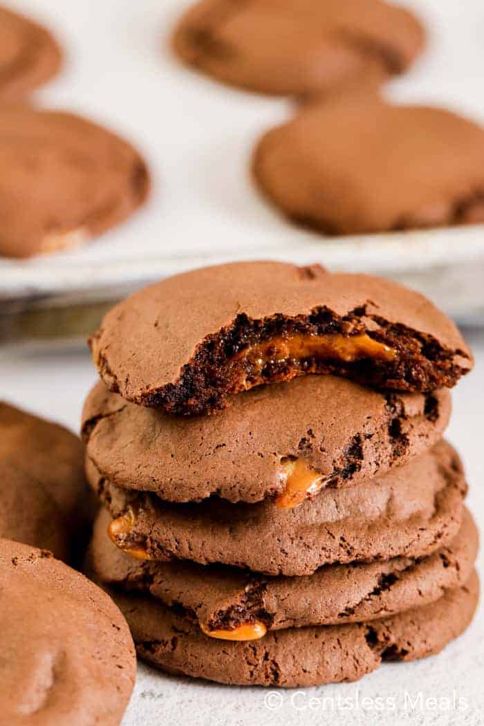 Stack of caramel chocolate cake mix cookies with a bite taken out of 1