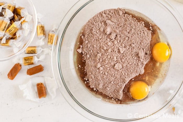 Ingredients for caramel chocolate cake mix cookies in a clear Bowl