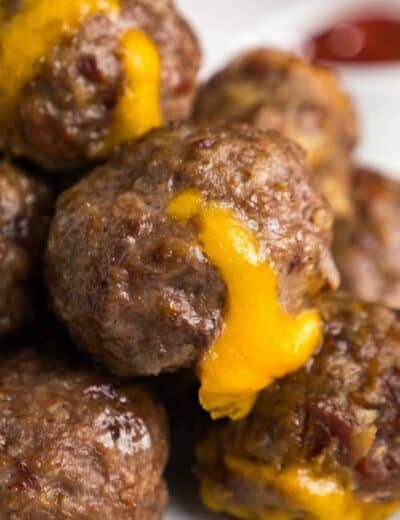 Bacon cheeseburger meatballs on a plate with cheese oozing out