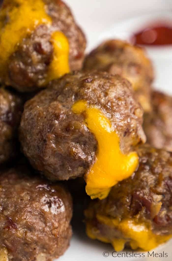 Bacon cheeseburger meatballs on a plate with cheese oozing out