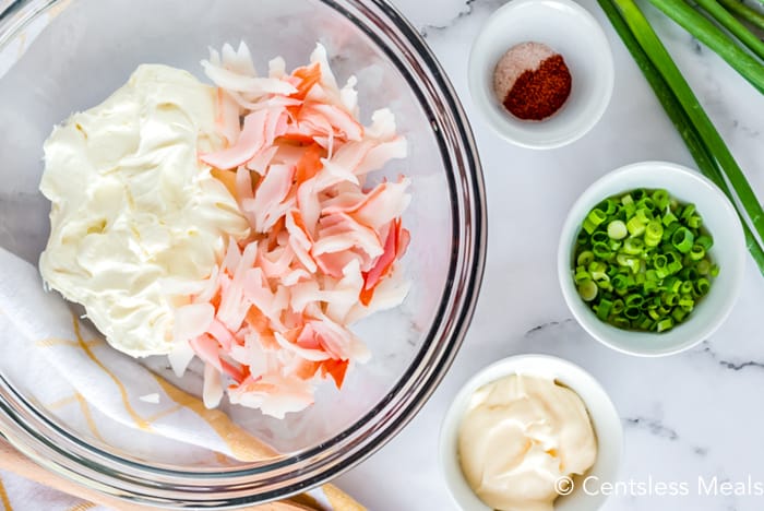 Ingredients for crab and cheese mixture in a glass bowl