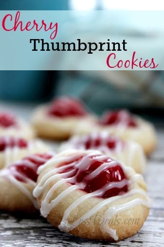 Cherry thumbprint cookies on a wooden board with a title