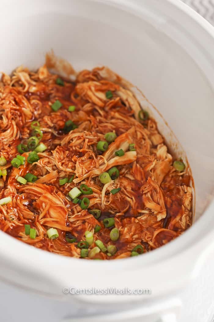 Crock-Pot BBQ beer chicken in a Crock-Pot garnished with green onion