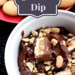 Snickers dip in a white bowl with cookies in the background and a title