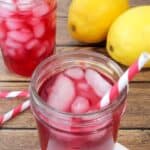 Copycat Starbucks passion tea lemonade in mason jars with straws and ice and lemons on the side