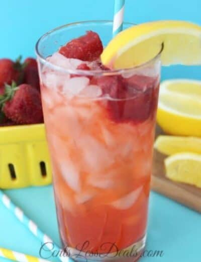 Red Robin's freckled strawberry lemonade in a glass with strawberries and lemon on the side