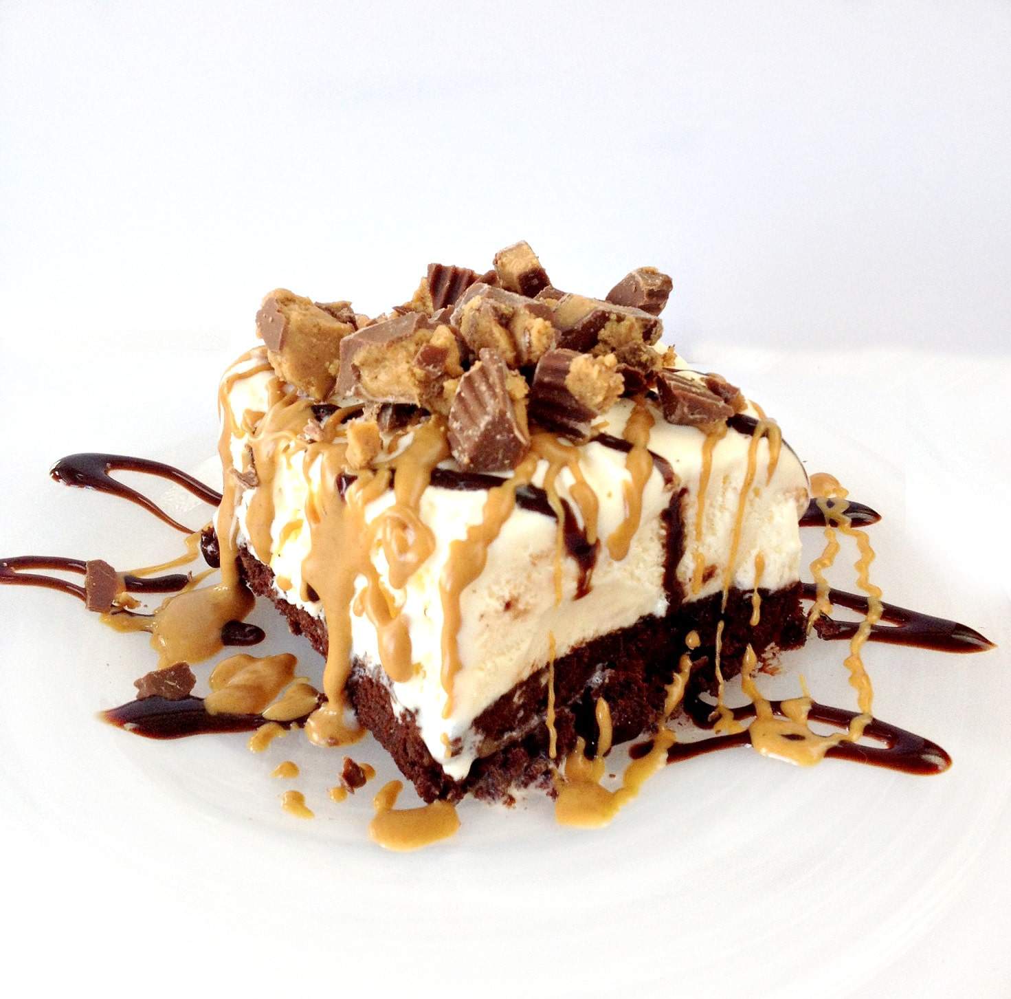 Reese's ice cream cake on a plate with Reese's Peanut Butter Cups on top