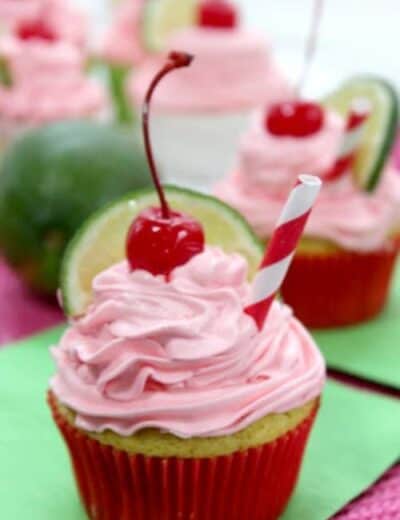 Cherry limeade cupcakes with icing, lime and cherries on top