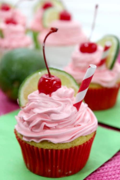 Cherry limeade cupcakes with icing, lime and cherries on top