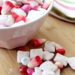 Strawberry Muddy Buddies recipe with some in a bowl and some on a wooden board