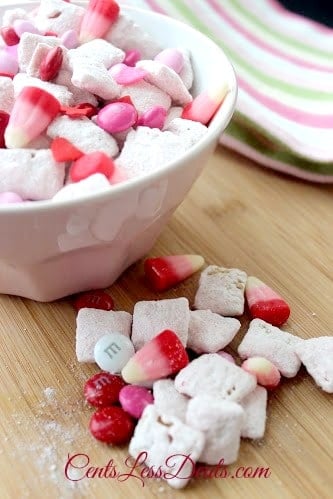 Strawberry Muddy Buddies recipe with some in a bowl and some on a wooden board