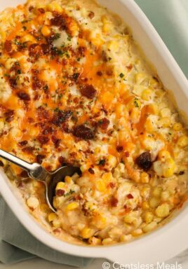 Corn casserole in a white casserole dish with a spoon