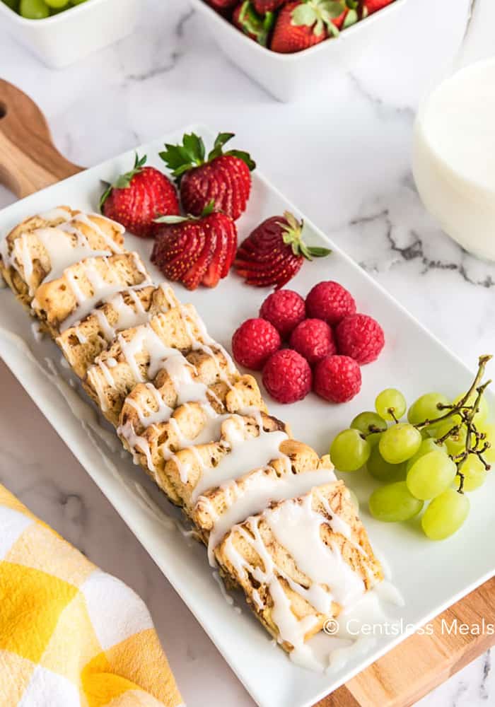 A white plate with strawberries raspberries and grapes with Crock-Pot cinnamon buns