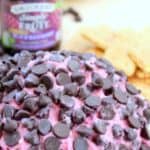 Black raspberry chocolate chip cheese ball with crackers and jam in the background