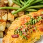 Parmesan crusted chicken on a plate with potatoes and green beans
