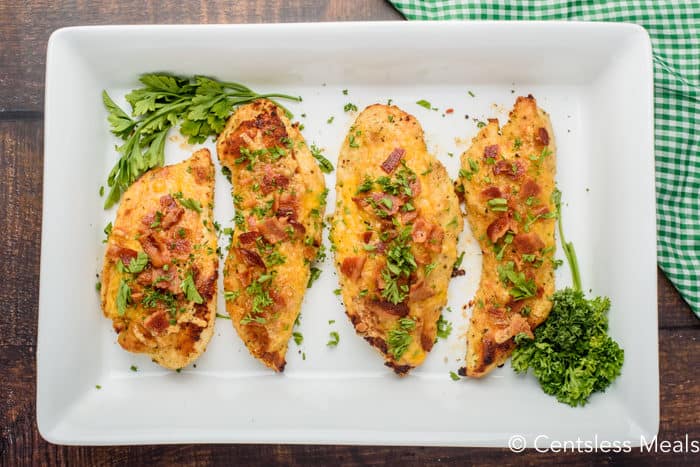 Parmesan crusted chicken on a plate with herbs as garnish