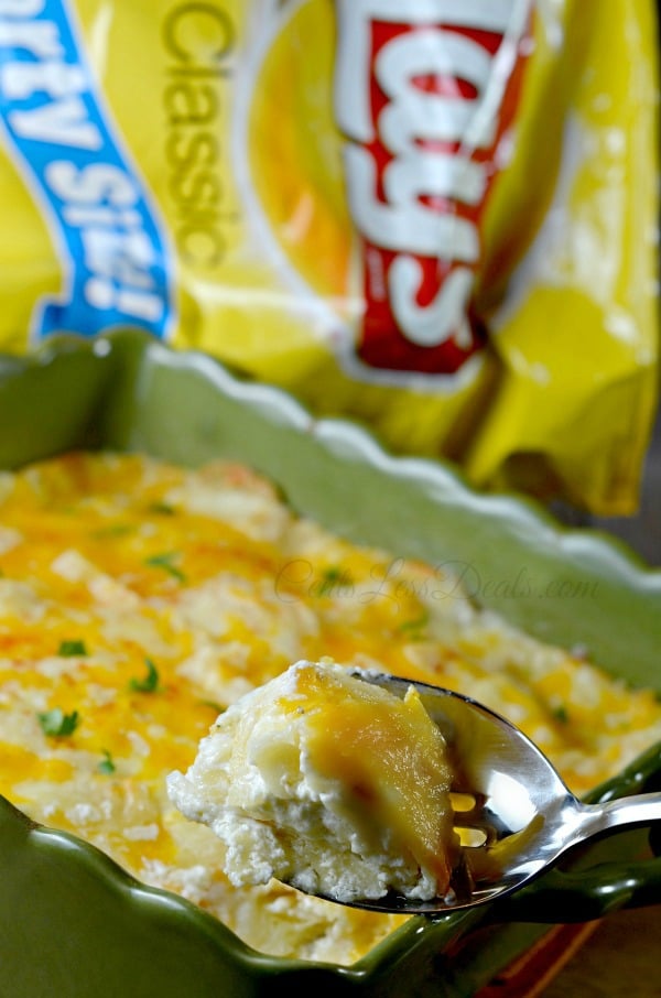 Dip on a spoon with Lays potato chips in the background