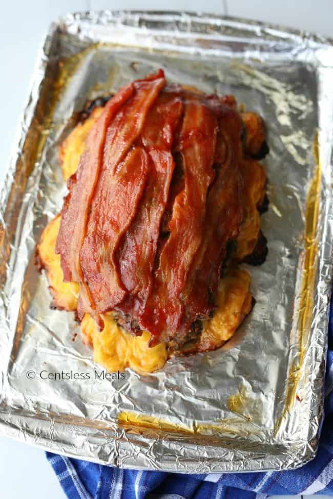 Cheeseburger meatloaf on a sheet pan with bacon on top