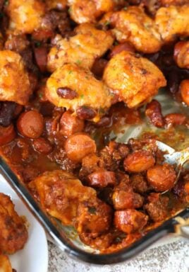 Chili cheese dog bake in a casserole dish with a spoon