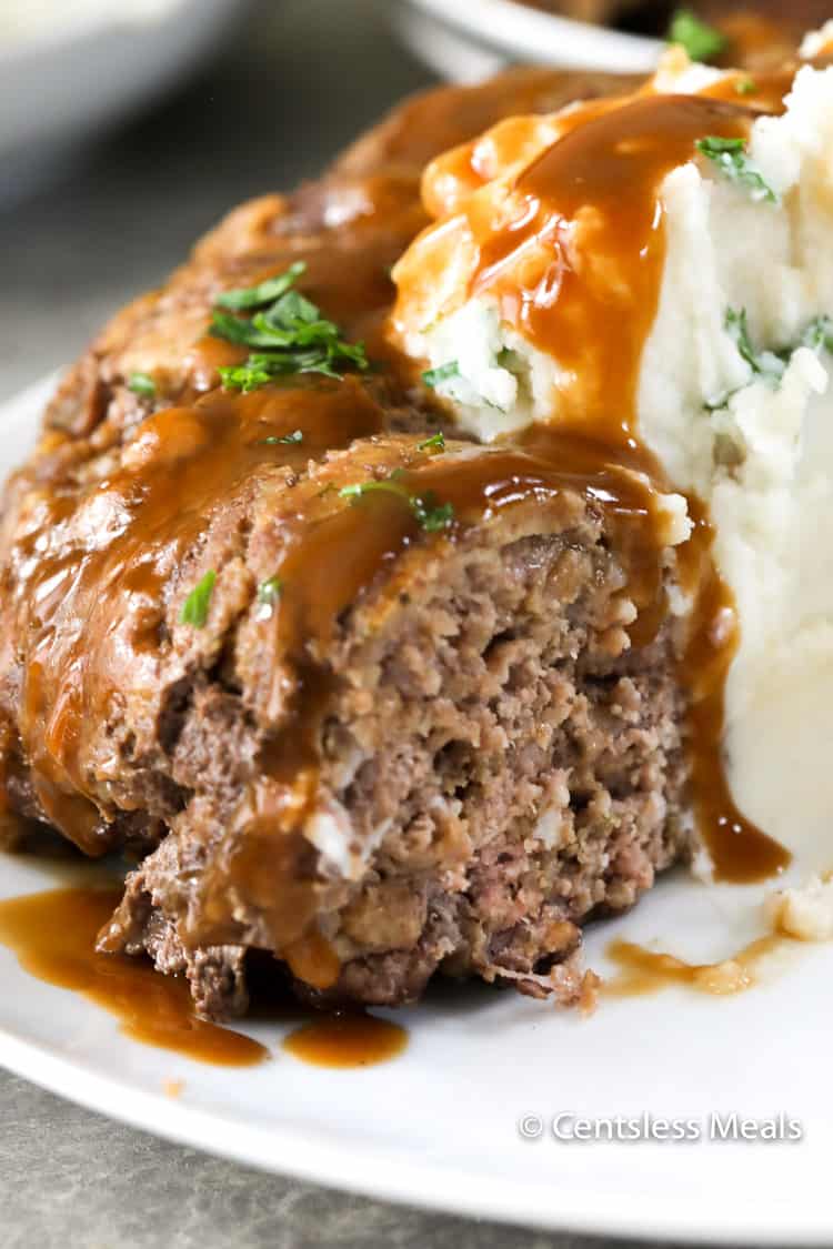 Stove top meatloaf on a plate with gravy and mashed potatoes